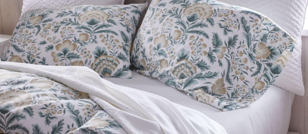 Bed made with floral pattern bedding.