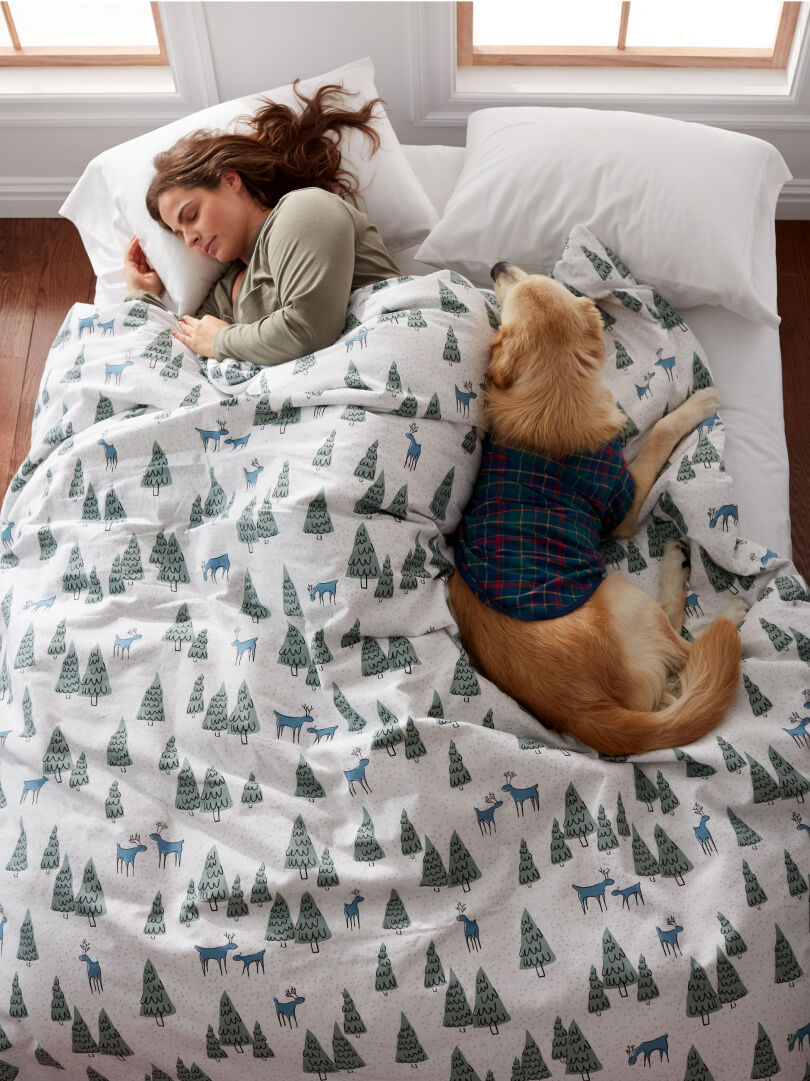 Woman and dog on tree-pattern duvet cover