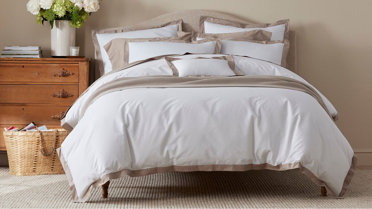 Image of bed with white and tan bedding