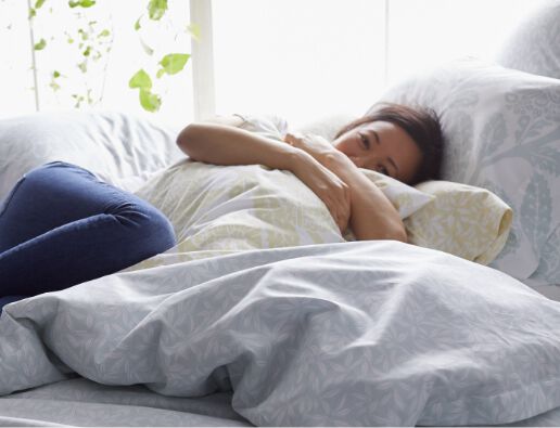 Woman hugging pillow in bed