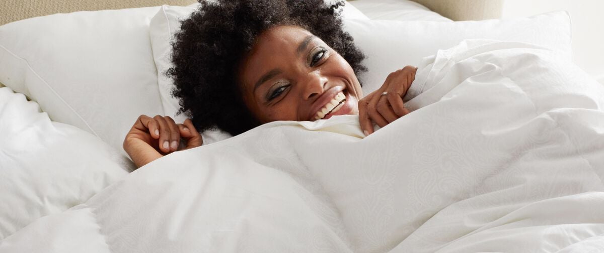 woman under white comforter
