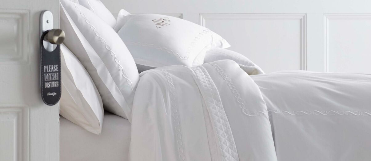 Bed made in all white bedding.