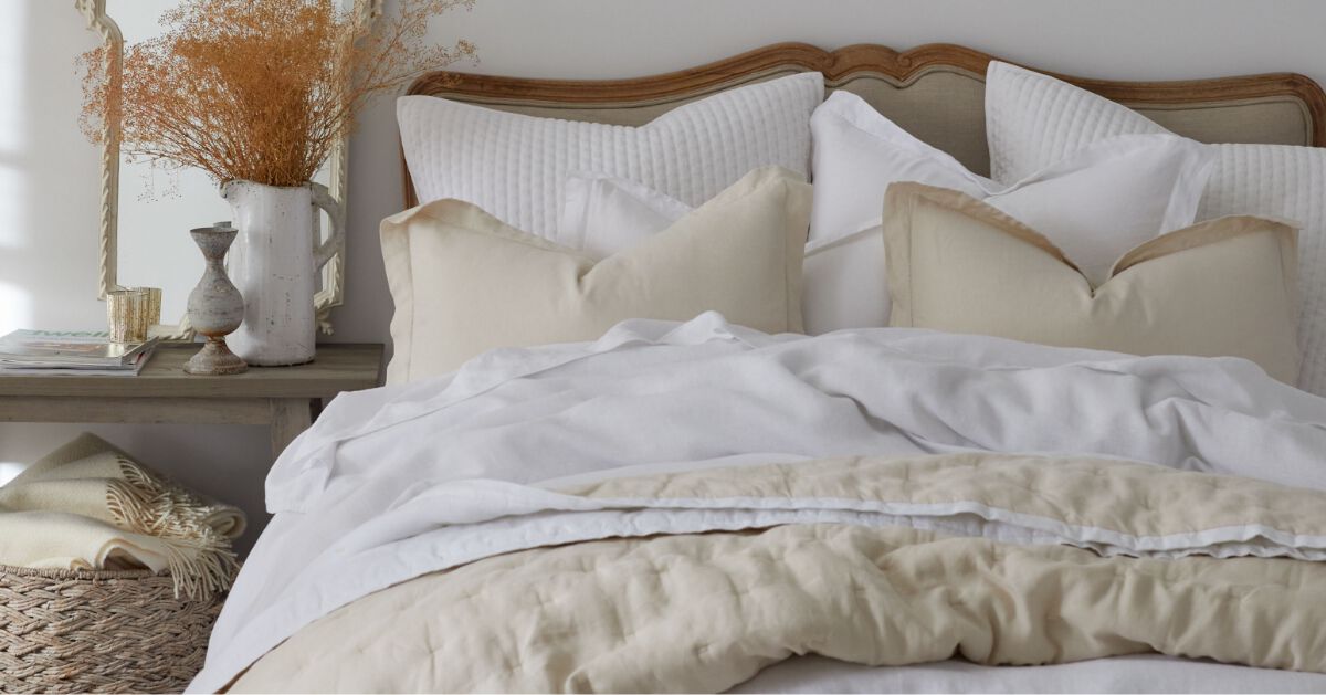 Image of bed with ivory and white linen bedding