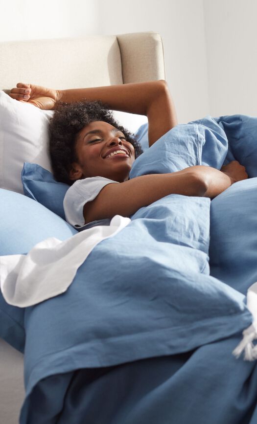 Woman Laying Under Blue Duvet Cover