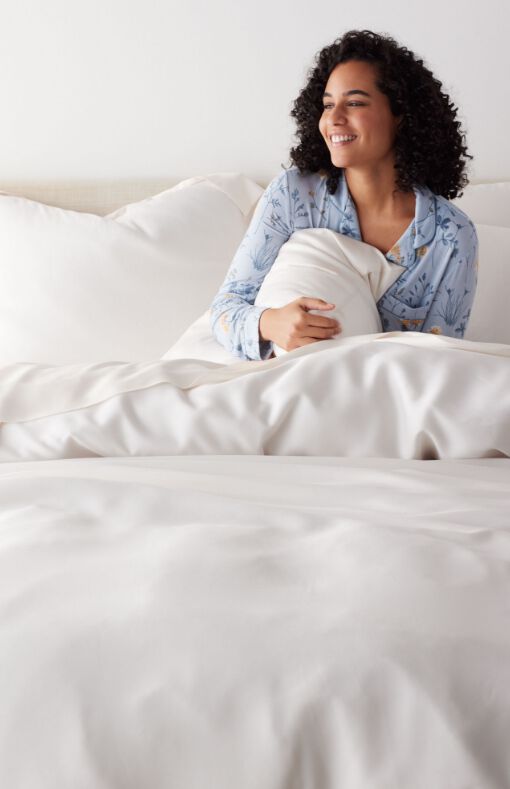 Woman in bed made of white lyocell bedding