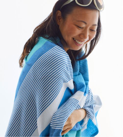Image of woman wrapped in blue striped flat weave towel