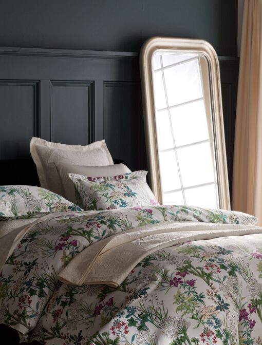 floral bedding with dark walls and a mirror