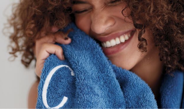 woman drying face with blue towel