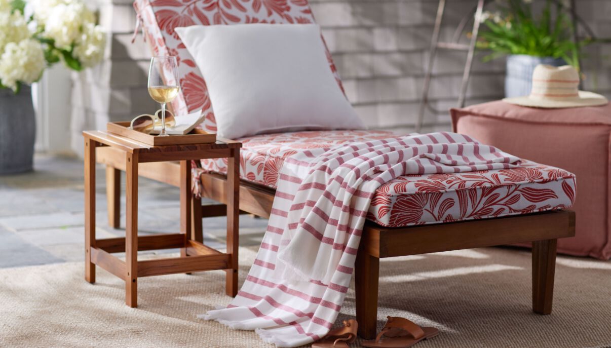 Lounge chair with red and white cushions and blanket