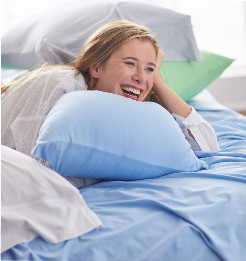 woman laughing on blue sheets