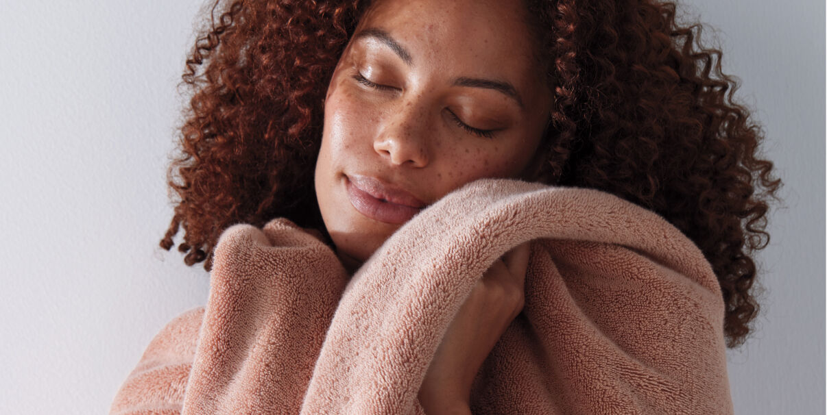 Image of Woman with soft towel to her face Image of Woman with soft towel to her face